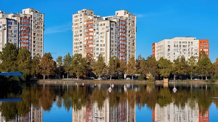 Tall blocks of flats by a lake, with balconies all the way up
